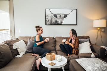 Two girls sitting on couch and talking